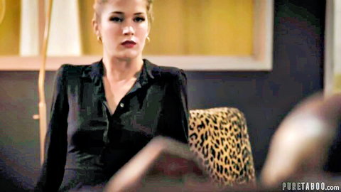 Seductive blonde in black blouse sits on leopard chair teasing with legs apart