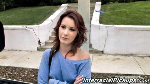 Skinny brunette white girl in off-shoulder blue sweater posing arms crossed outdoors