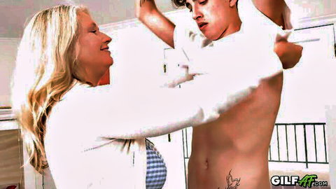 Blonde GILF smiles teasingly while lifting young stud's shirt exposing his toned abs and tattoo
