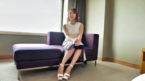 Glamorous Asian woman in short skirt and high heels sitting seductively