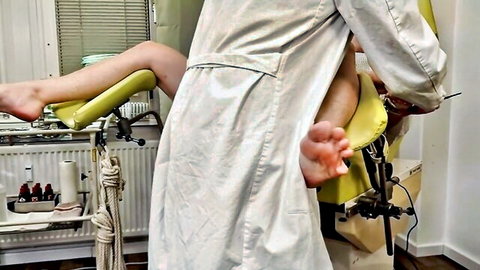 Erotic medical exam: doctor in white coat examines spread-legged patient intimately