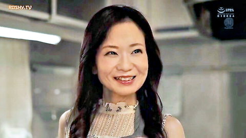 Smiling mature Japanese MILF in sheer lace top showing cleavage