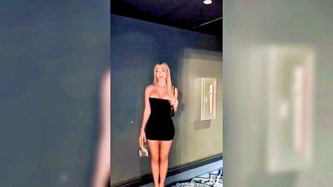 Sexy blonde posing in tight black tube mini dress showing off her long legs and curves