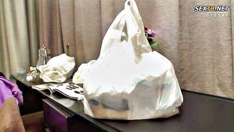 White plastic shopping bag on dark desk in Japanese bedroom with beige curtains and vase