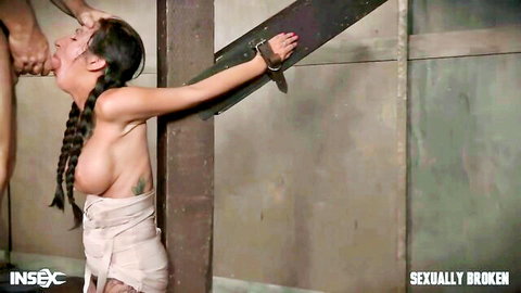 Bound submissive brunette with bare tits gets face gripped by man in BDSM bondage