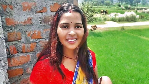 Indian countryside girl in red sari smiling in rural village setting