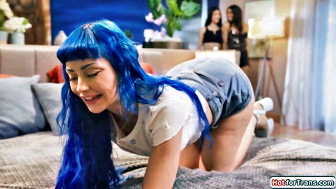 Zariah Aura with blue hair on all fours in white top and denim shorts, smiling