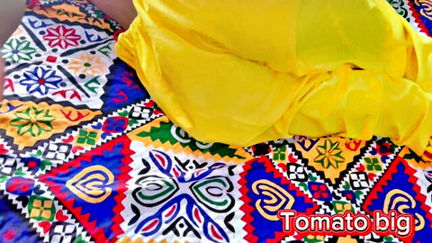 Hot Indian bhabhi in yellow saree posing seductively on colorful blanket