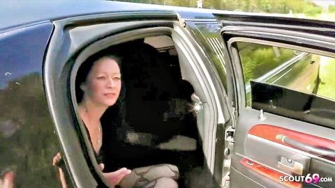 Mature woman smiling seductively from open black limo door in car tease