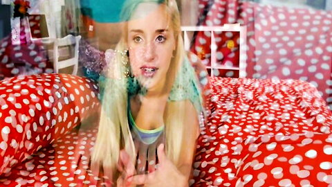 Blonde teen babe with open mouth posing playfully on polka dot bed