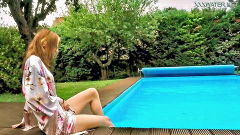 Petite fair babe in open floral robe sitting poolside dipping legs in blue water teasing