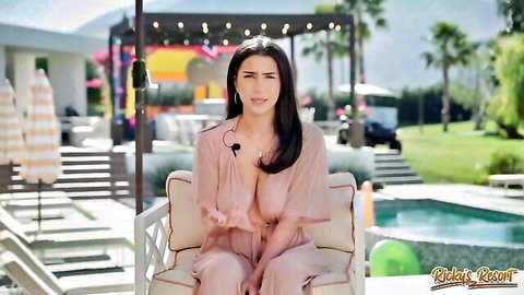 Curvy olive brunette with huge tits in sheer pink top at poolside resort interview