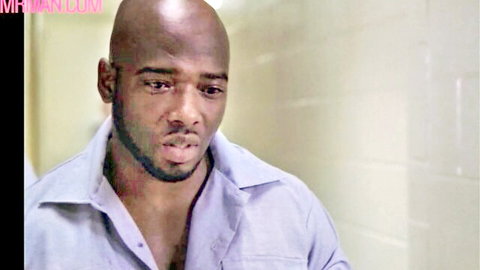 Bald Black man with intense gaze, open shirt revealing chest