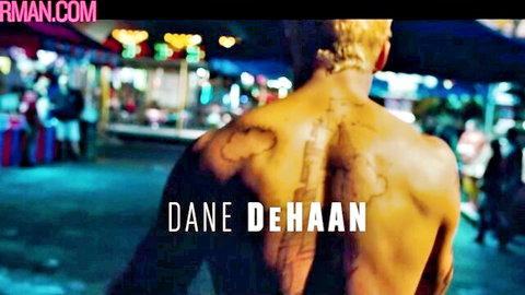 Dane DeHaan shirtless, tattooed muscular back in neon-lit night scene