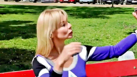 Blonde MILF in tight purple top puckers lips seductively on park bench selfie