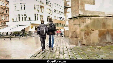 Two slim twinks walking arm-in-arm in rainy European street, preview for sexy fuck session