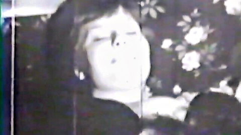 Vintage close-up of ecstatic short-haired woman in antique adult film, eyes half-closed mouth open