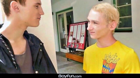 Two cute white gay teens face-to-face in hallway, one in yellow McFry shirt