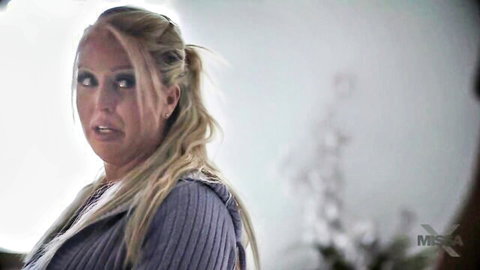 Blonde MILF in open hoodie showing deep cleavage with surprised expression
