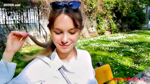 Cute Japanese model Liz smiling outdoors in white blouse, ponytail hair