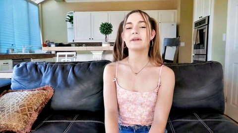 Skinny teen brunette with small tits in tight pink camisole and jeans sitting seductively on couch