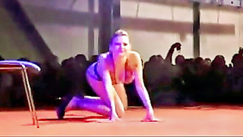 Blonde babe in skimpy bikini posing provocatively on stage in men's club
