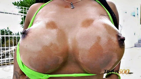 Evelyn Emperatriz topless with huge oiled tits in green bikini outdoors