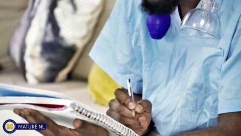 Bearded black doctor in scrubs with purple breast pump fetish toy