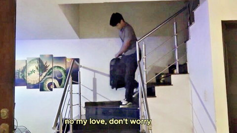 Young Asian stepson carrying suitcase upstairs in taboo family scene