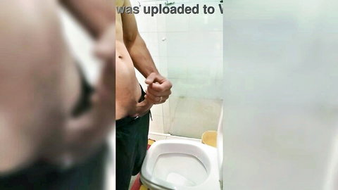 Blurry amateur guy gripping his thick cock peeing into bathroom toilet solo homemade.