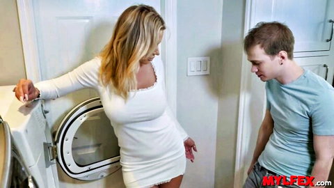 Blonde stepmom in short white dress bent over washer with stepson