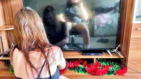 Stepsister in black dress watches steamy reflection of intimate couple on TV