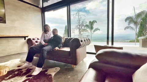 Best friends intimately lounging on couch in casual clothes, teasing hookup vibe