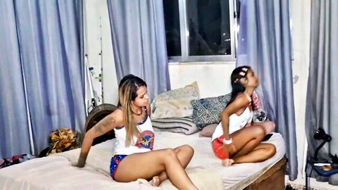 Two naughty ebony Brazilian babes in tank tops and shorts teasing on bed