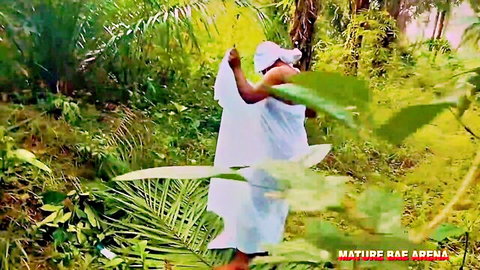 Mature ebony babe teasing in jungle holding white sarong over her big ass and curves