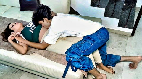 Boyfriend on top of pregnant girlfriend kissing her passionately on couch