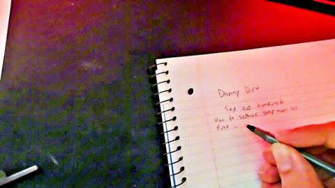 Amateur hand scribbling 'sex sex sex' repeatedly in yellow notebook closeup