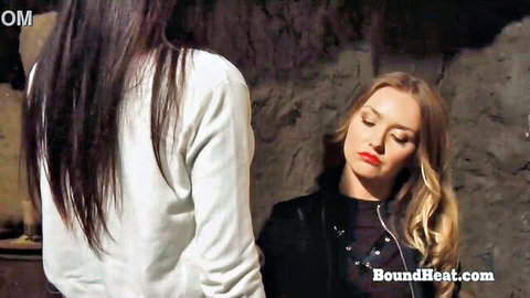 Blonde in leather jacket and brunette in white hoodie in intimate lesbian pose