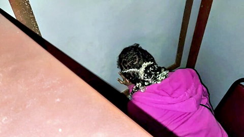 Black woman in pink hoodie bending over at glory hole first time