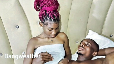 Ebony woman with pink braids and man in intimate bed moment, Bangweather