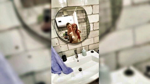 Topless redhead woman and man posing in bathroom mirror selfie