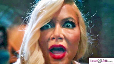 Blonde woman with wide eyes and red lips in intense all-girl sex battle