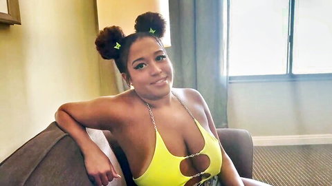 Curvy ebony girlfriend in yellow harness top, space buns hairstyle