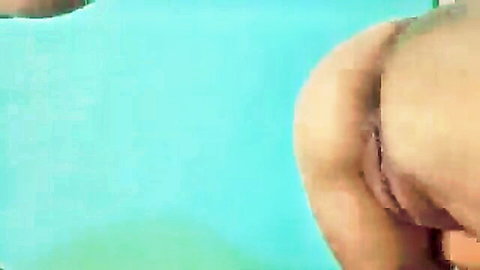 Closeup of woman's spread ass cheeks revealing tight pink anus and wet shaved pussy