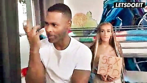 Blonde with long hair holds SEX sign teasing muscular black stud in interracial bedroom promo