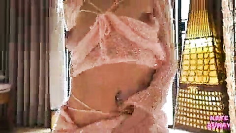 Sensual brunette babe in sheer pink sparkly dress revealing small tits and navel piercing