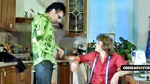 Tim Cob with mature woman in red top, sewing pants in intimate kitchen moment