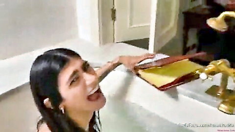 Mia Khalifa wet in bathtub, teasing with open mouth near sink