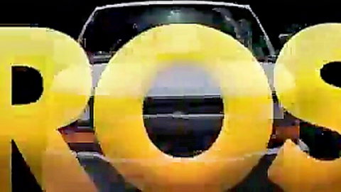 Glowing yellow ROSS letters overlay massive car in dark night parking lot