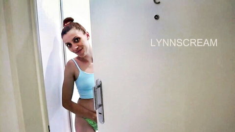 Brunette woman peeking from door in blue tank top and green panties, teasing affair